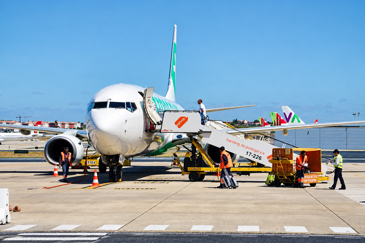 Airplane boarding at airport with passengers and crew on the tarmac.